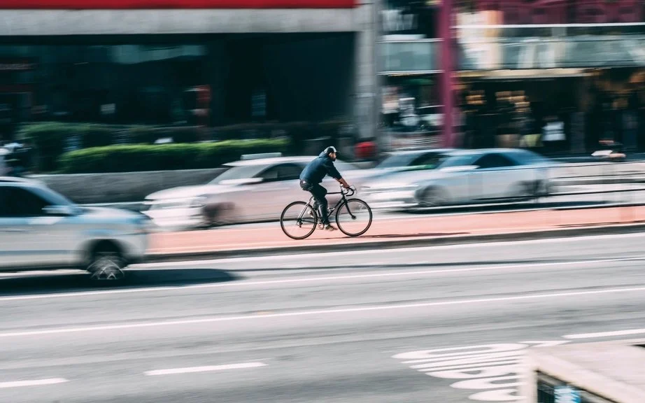 Ciclista circulando por una calle de la ciudad junto al tráfico