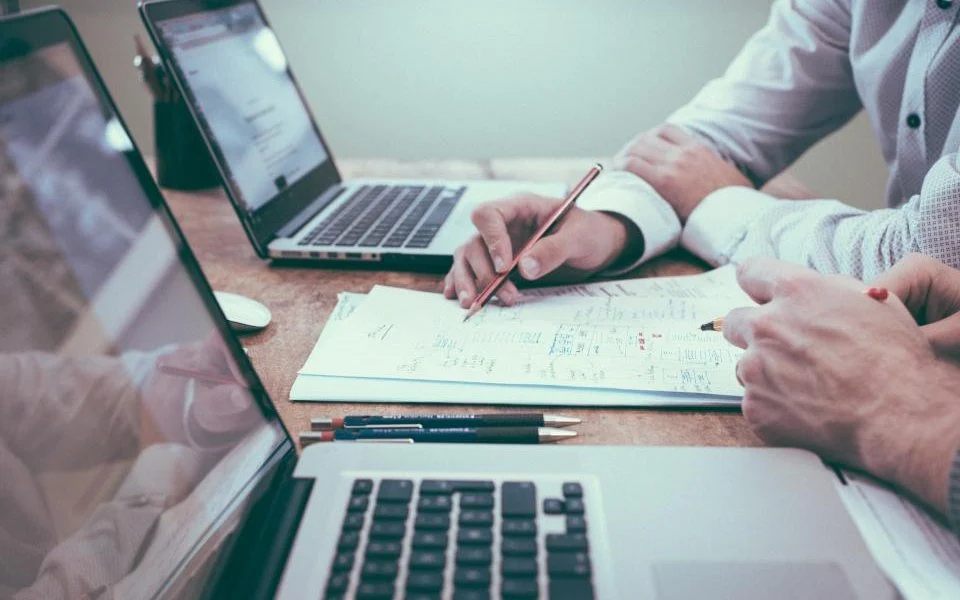 Personas trabajando con portátiles y documentos: cómo trabajar en la DGT